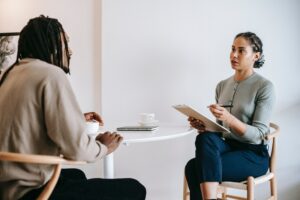 two people talking at a desk