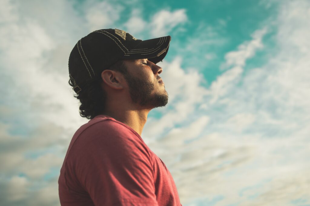 A man looks up at the sky to represent addiction treatment and substance use disorder. 