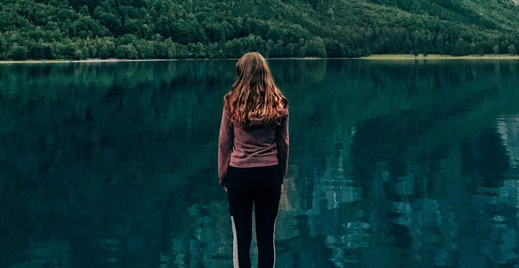 A woman stands looking over a lake to represent withdrawal from pristiq