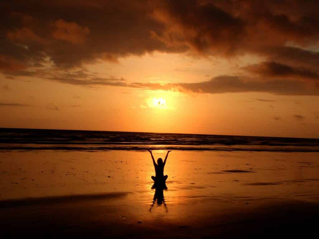 An image of someone meditating on the beach | Self Care in Recovery