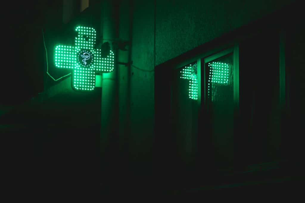 An image of a pharmacy neon light on a dark street | Street names for drugs