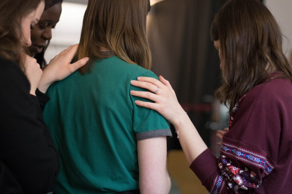 people praying at a faith-based rehab program