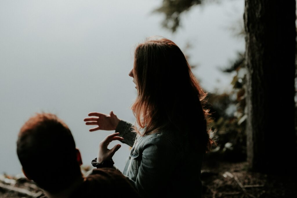 Two people are talking near a lake to represent the relationship between addiction and dopamine. 