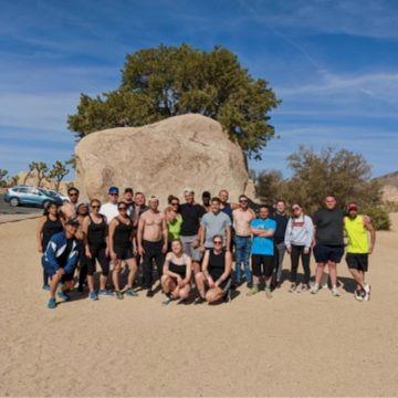 People taking a group photo in front of a rock