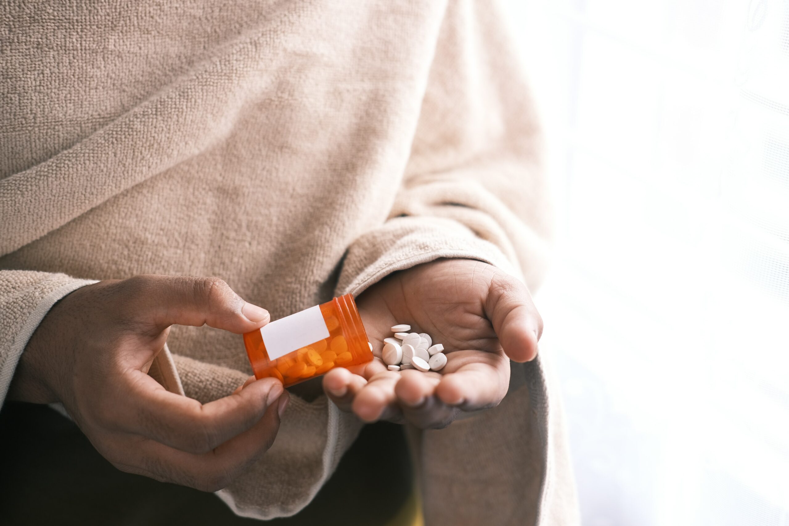 Woman is shaking prescription Wellbutrin antidepressant into her hand.