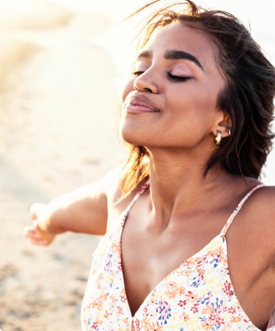 women smiling into the air facing the sun