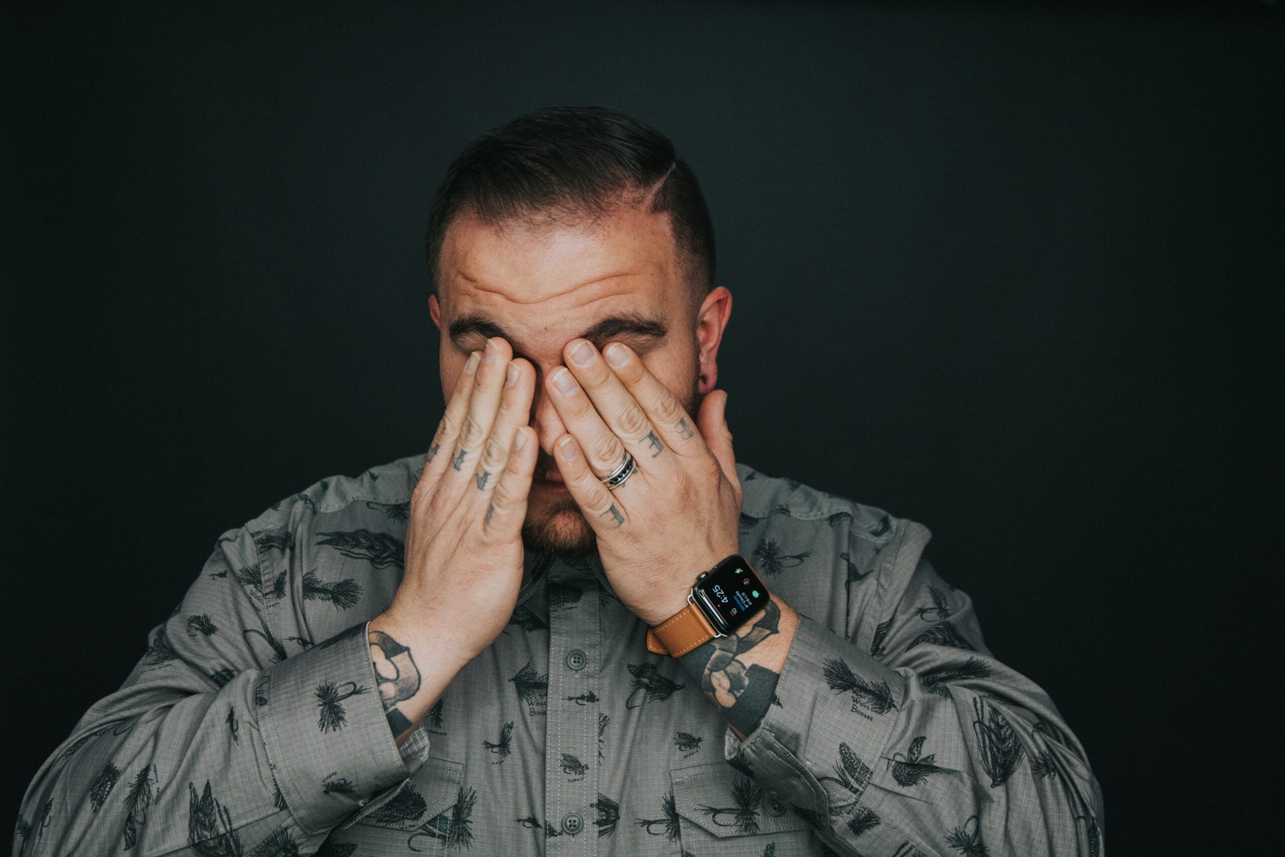 a man has his hands on his face, suffering from a headache and wondering if Xanax can cause headaches