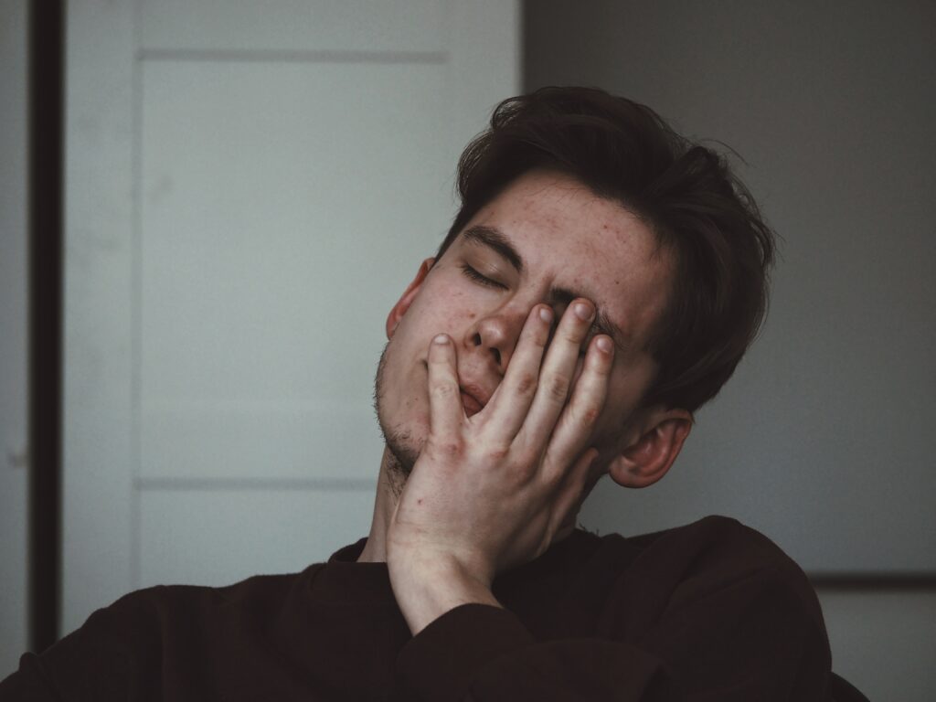 an image of a man with his head in his hand to represent prescription drug rehab treatment center in california.