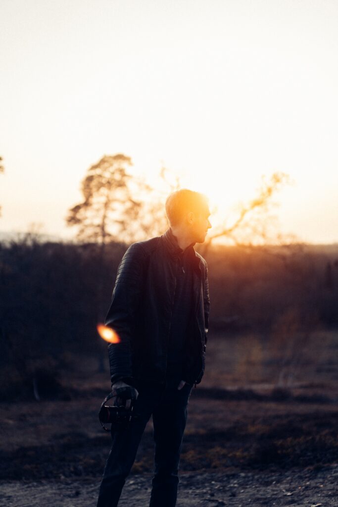 a man stands with his hands in his pockets at sunset to represent heroin detox and withdrawal.