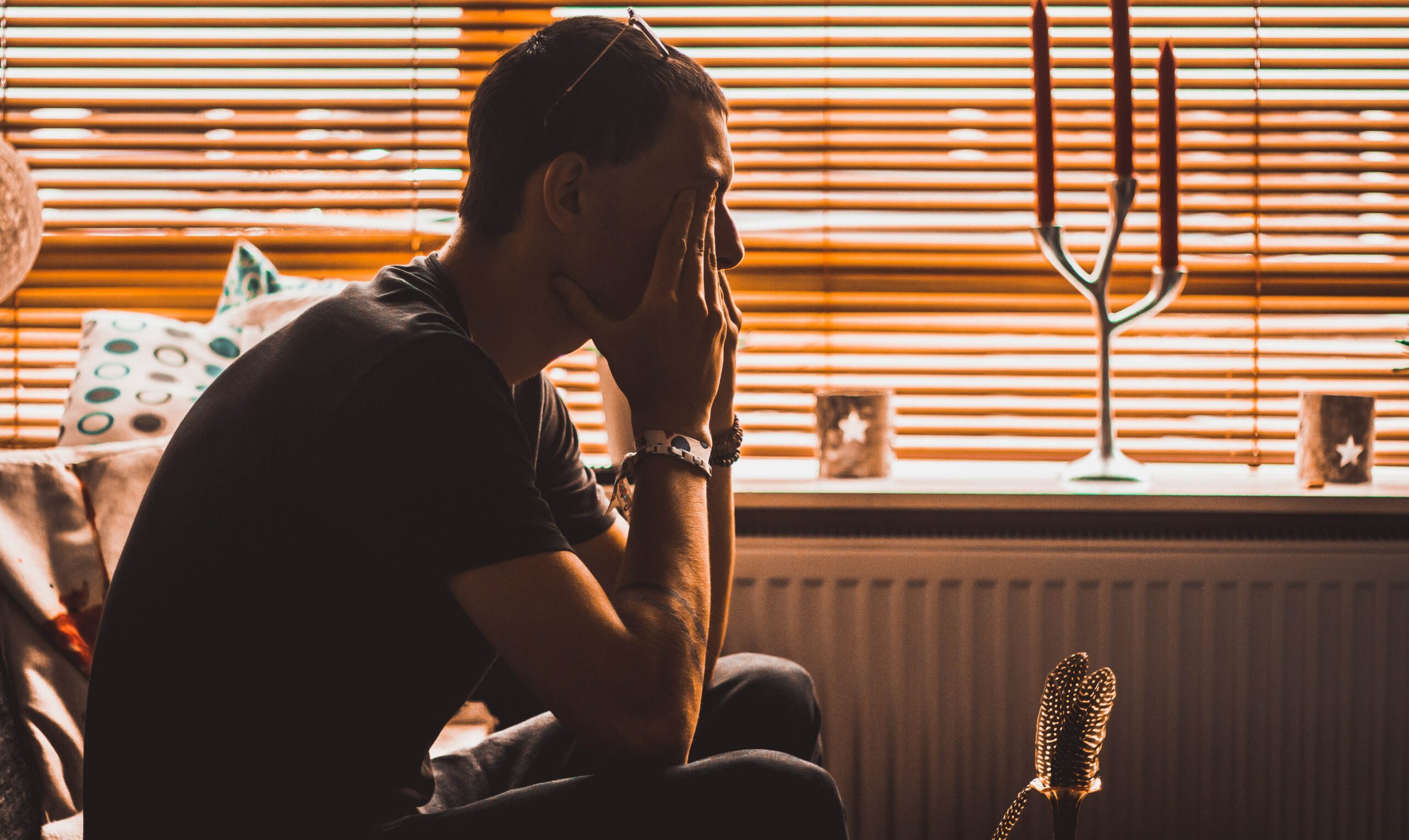 a man sits with his head in his hands to represent meth rehab and detox.