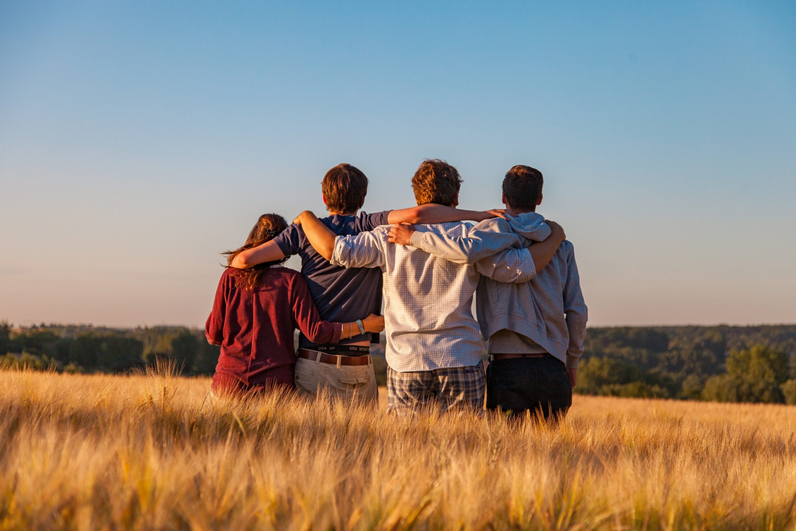 a group of people stands with their arms around each other to represent a partial hospitalization program in orange county california.