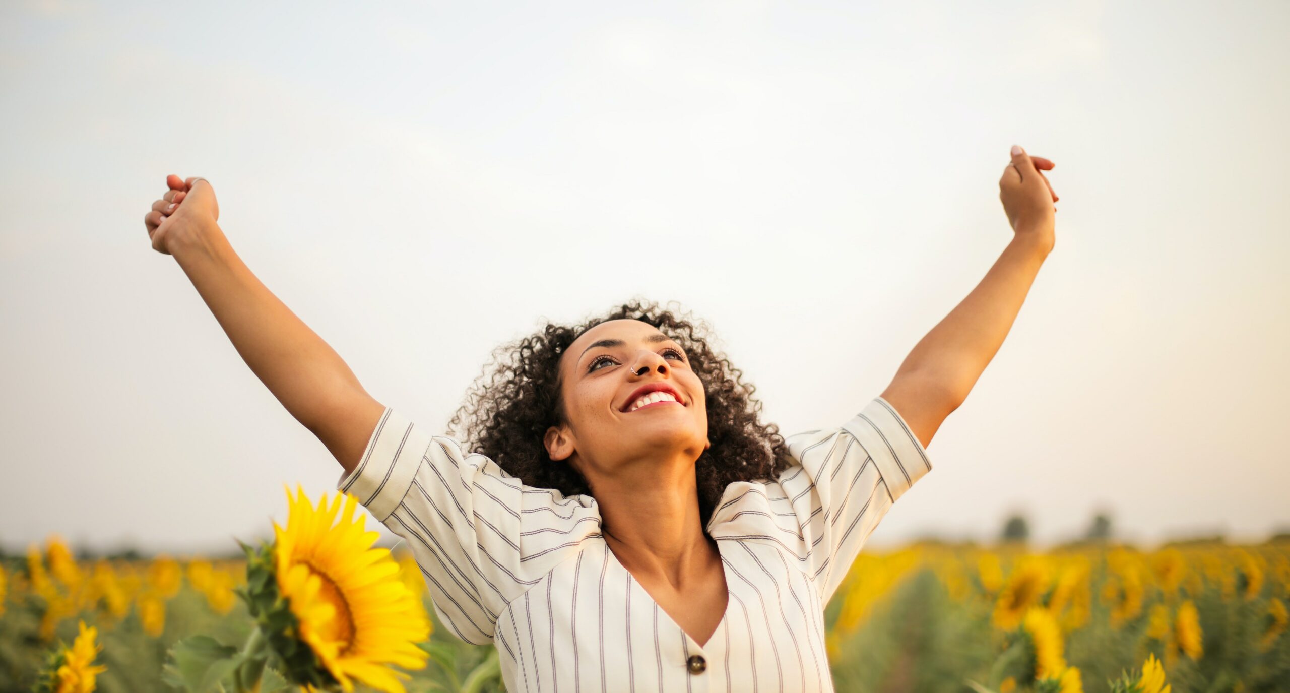 A woman is celebrating success with her hands up to represent the success rate of rehab.