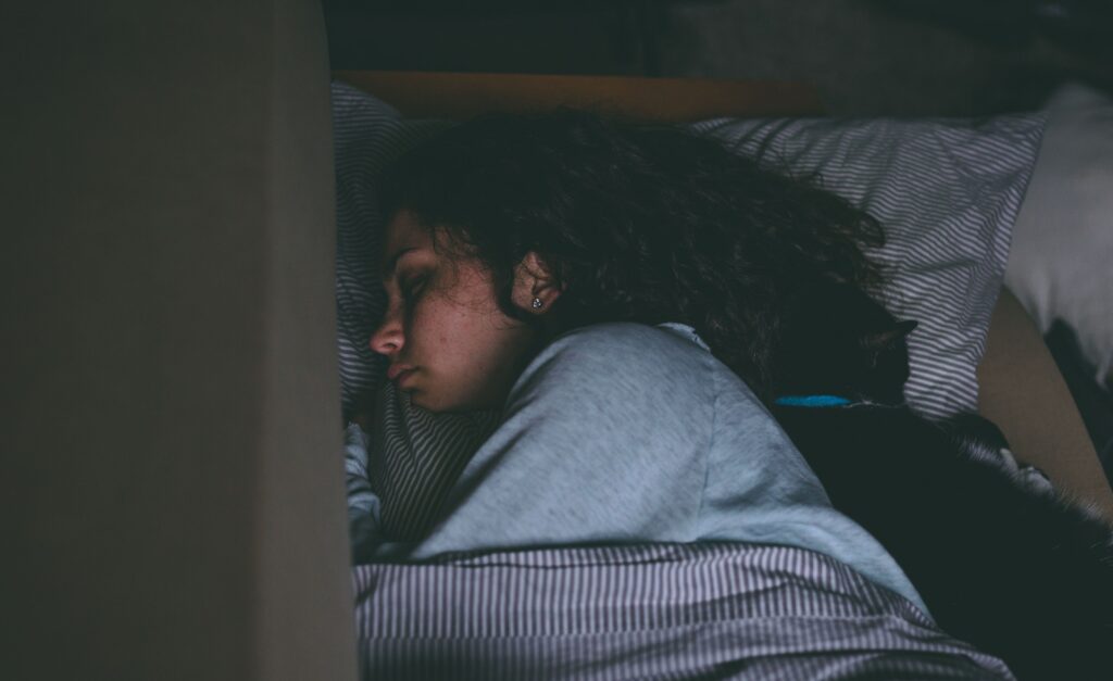 a young woman lies in bed to represent the physical effects of meth on the body.