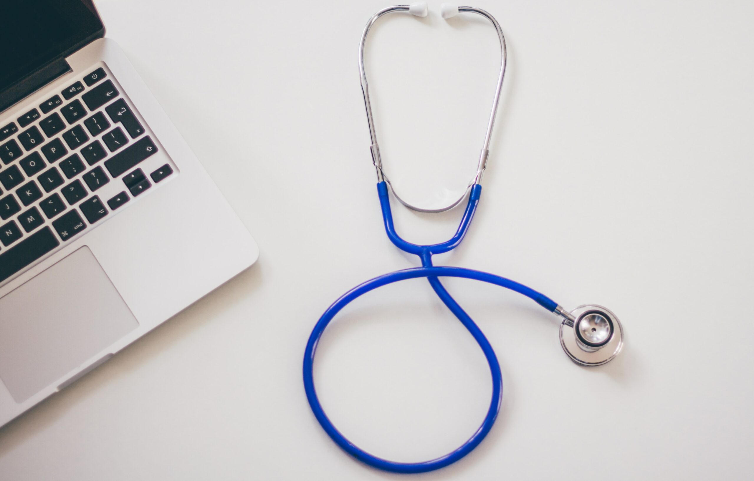 stethoscope on a table next to a laptop