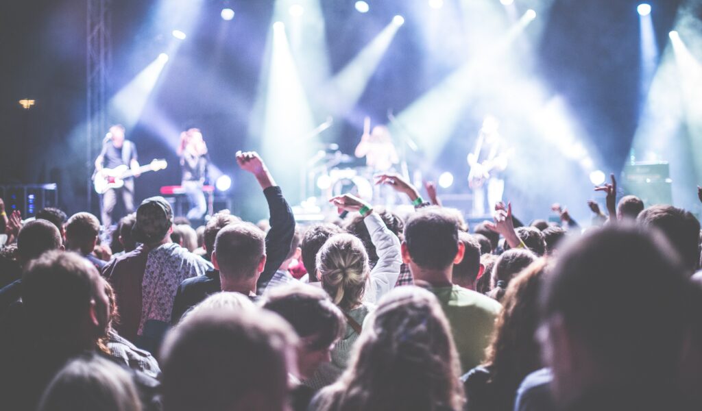 A concert with people who have their hands up in the air to represent live music as one of the 5 Best Non-Drinking Activities in Newport Beach and sober activities in newport beach.