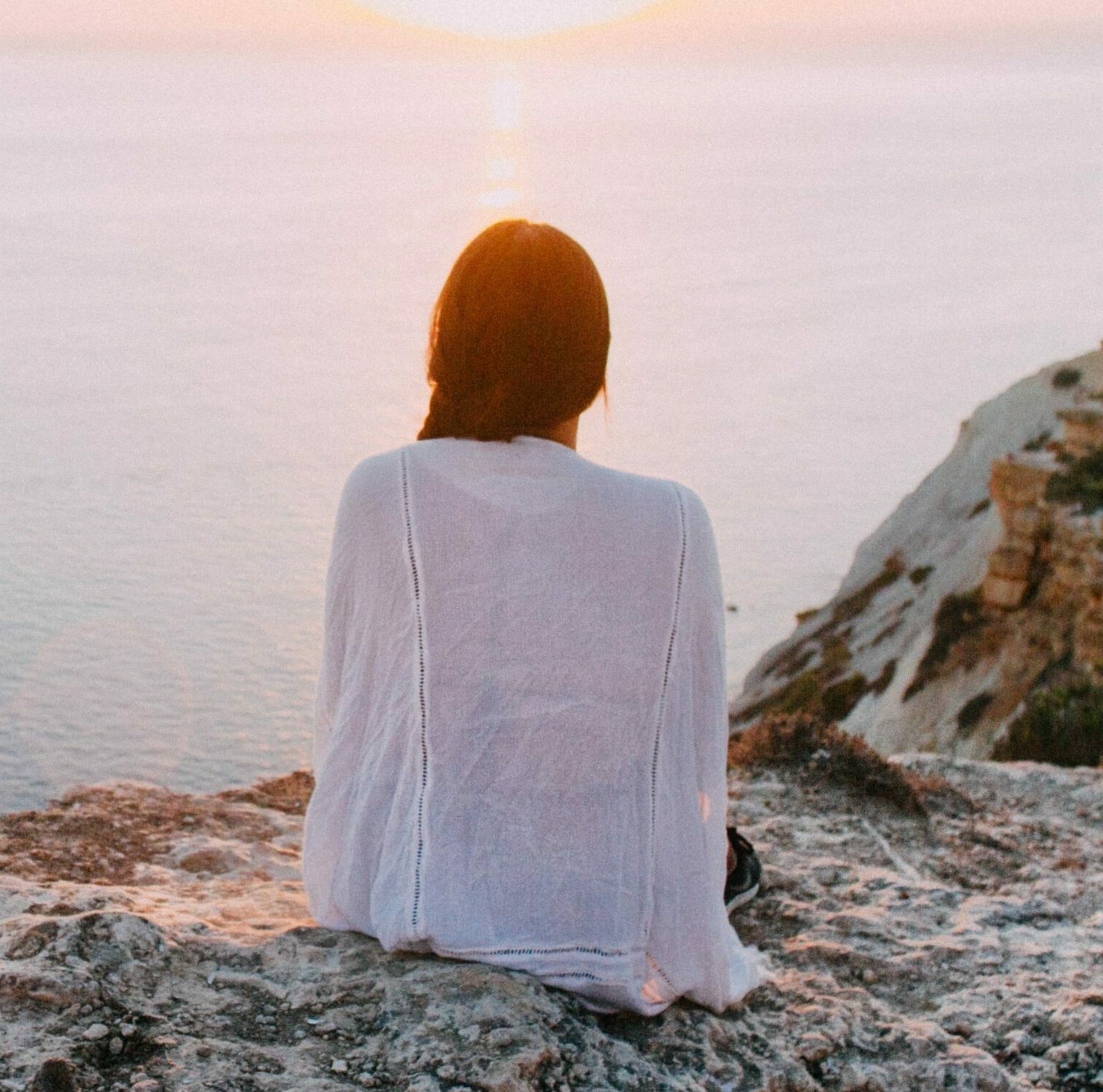 a woman is sitting on a beach to represent prescription drug rehab. .