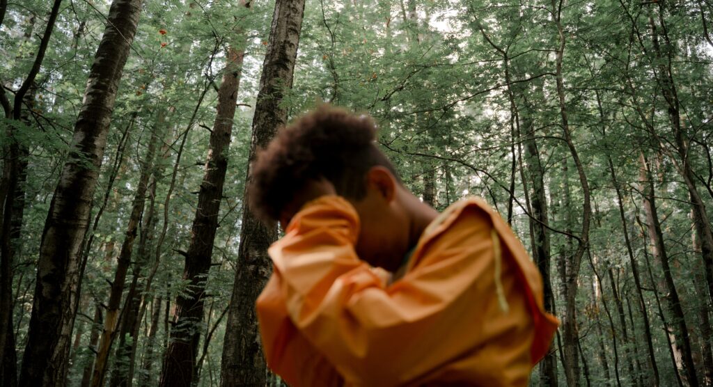 a young man stands with his head in hands to represent opiate addiction rehab.