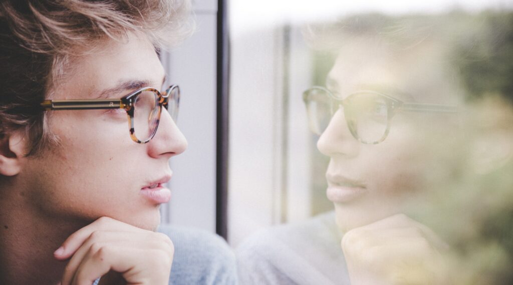 a man looks out a window to represent the question: is fentanyl an opioid?