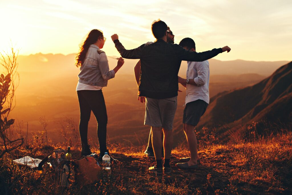 a group of people are on a hill at sunset celebrating rehab in long beach california.