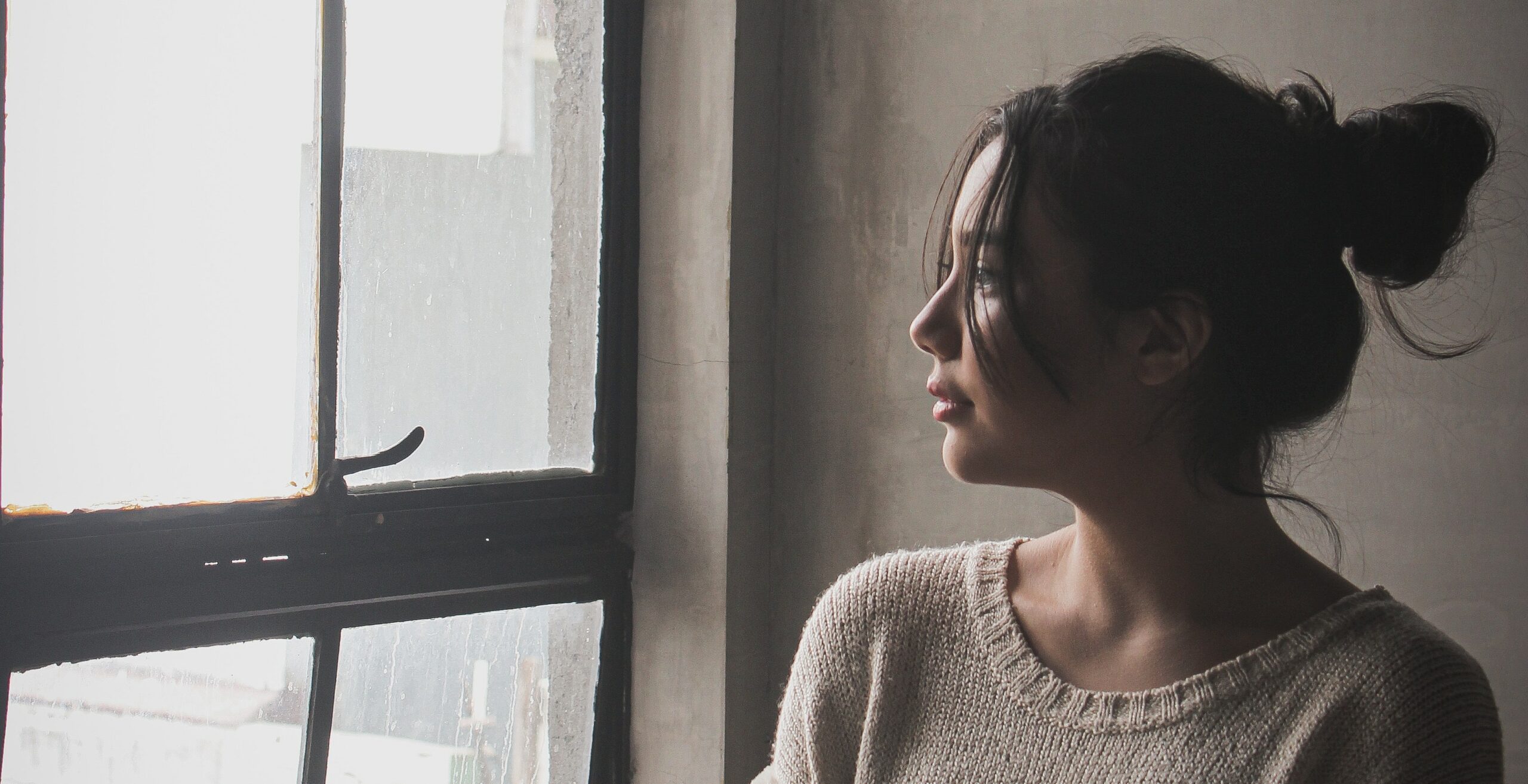 a woman looks out a window representing quaalude pills