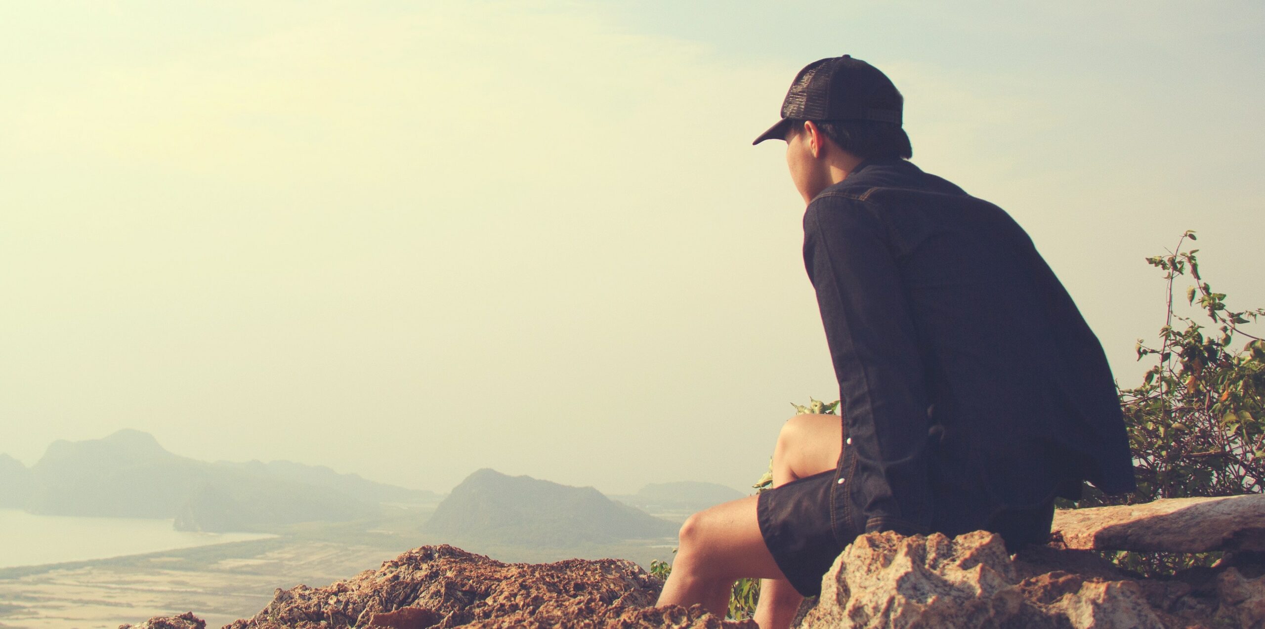 a man is sitting on a hill to represent inpatient rehab in orange county california.