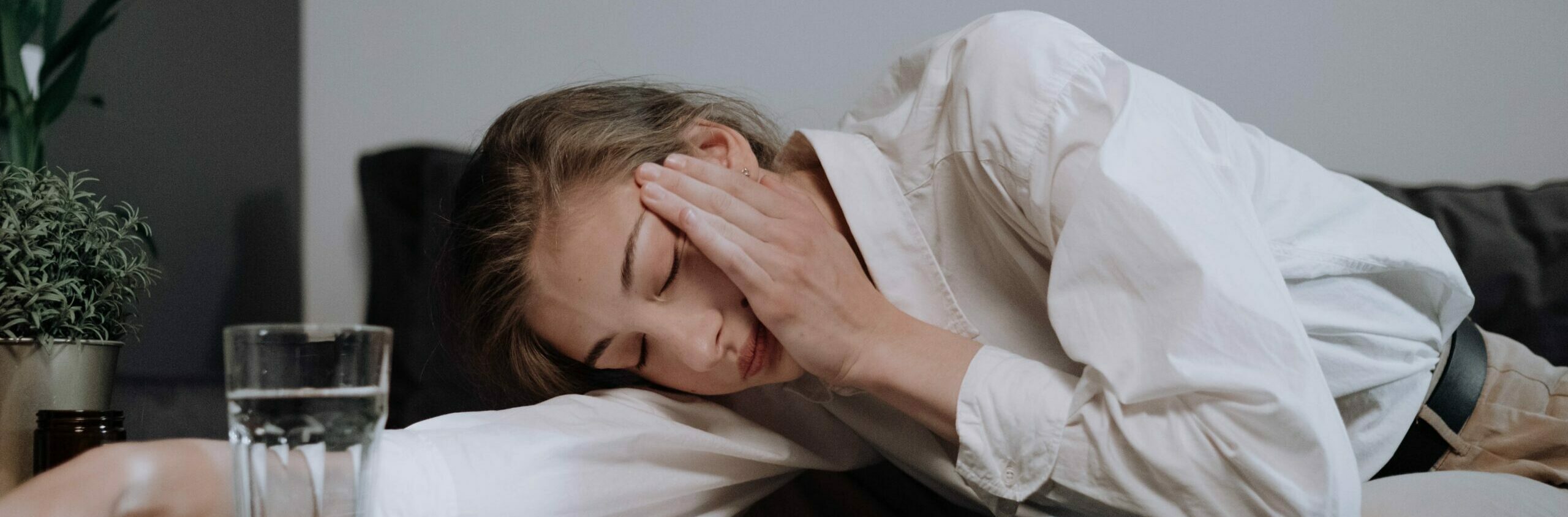 a woman is lying her head down to represent symptoms of dopesick.