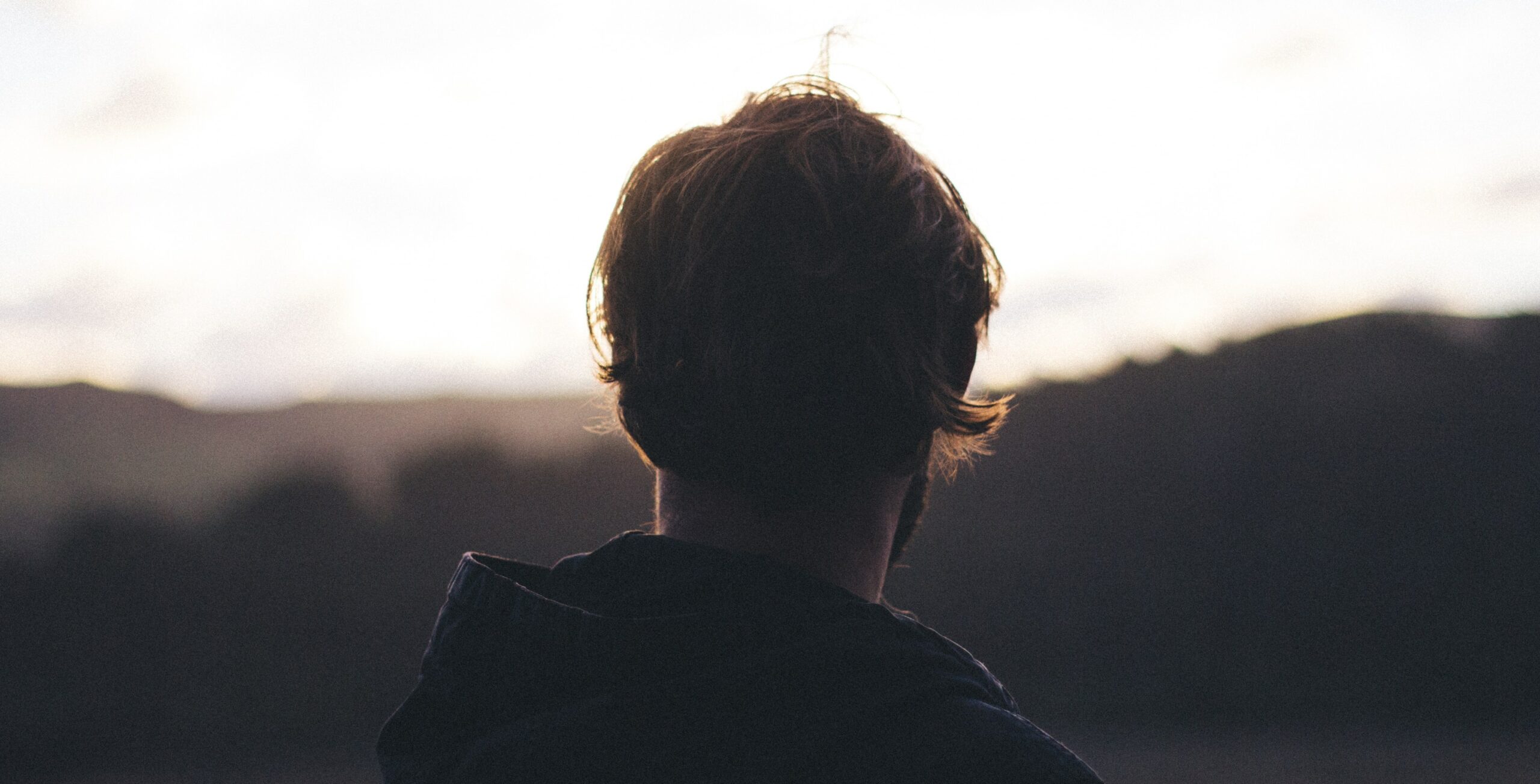 A man looks out at a beach landscape in California to represent symptoms of drug withdrawal.