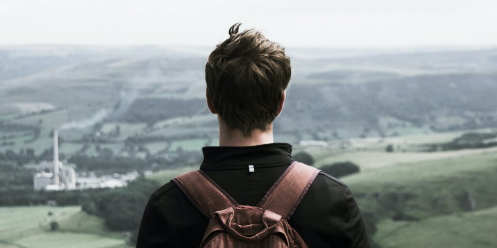 A man is looking out at California scenery to represent the question, "how does drug addiction start?".