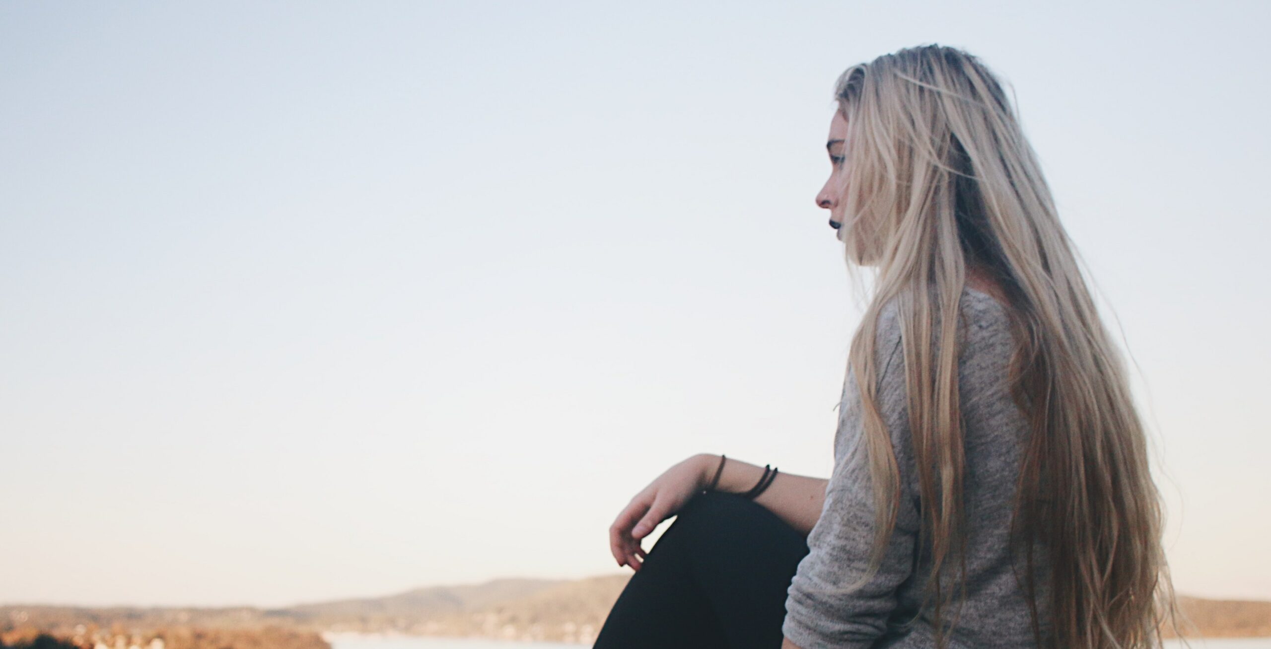 A woman sits near a California beach representing alcohol withdrawal seizures timeline.