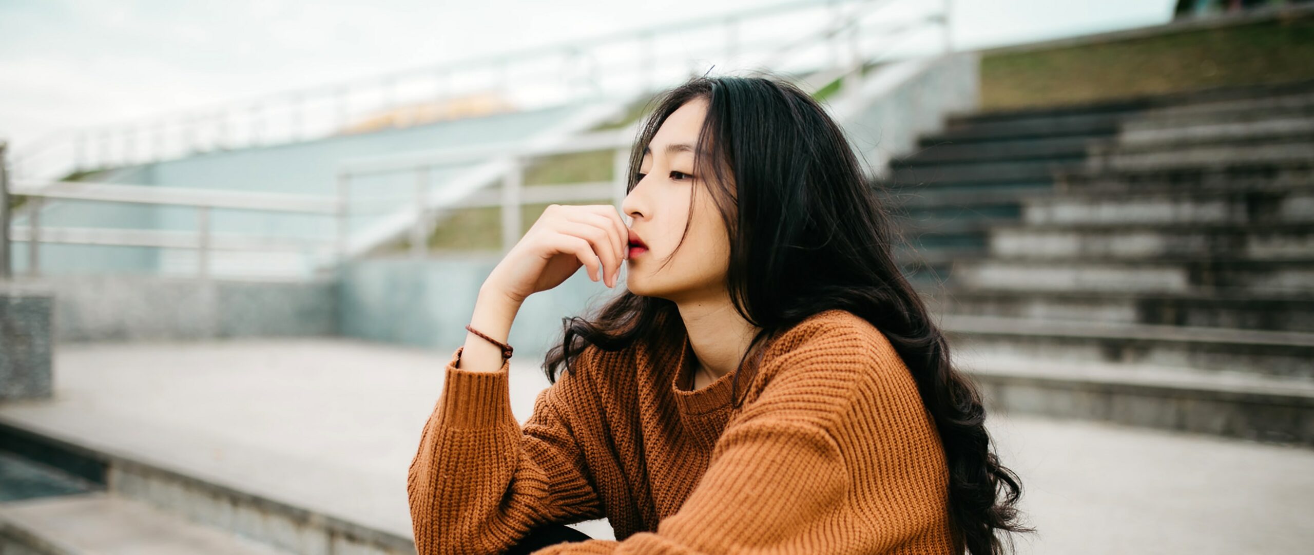 woman sits thinking representing alcohol addiction