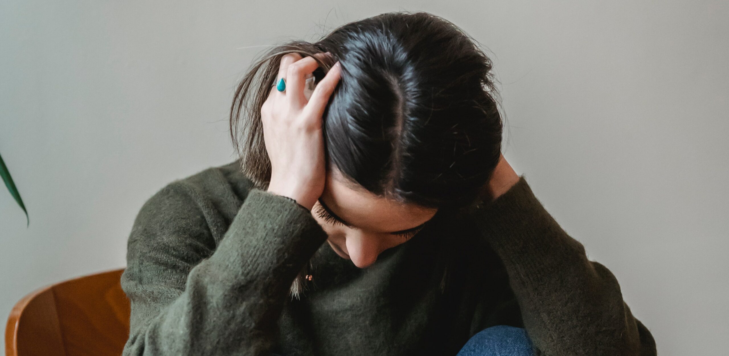 a woman has her hands on her head representing alcohol withdrawal seizures timeline.