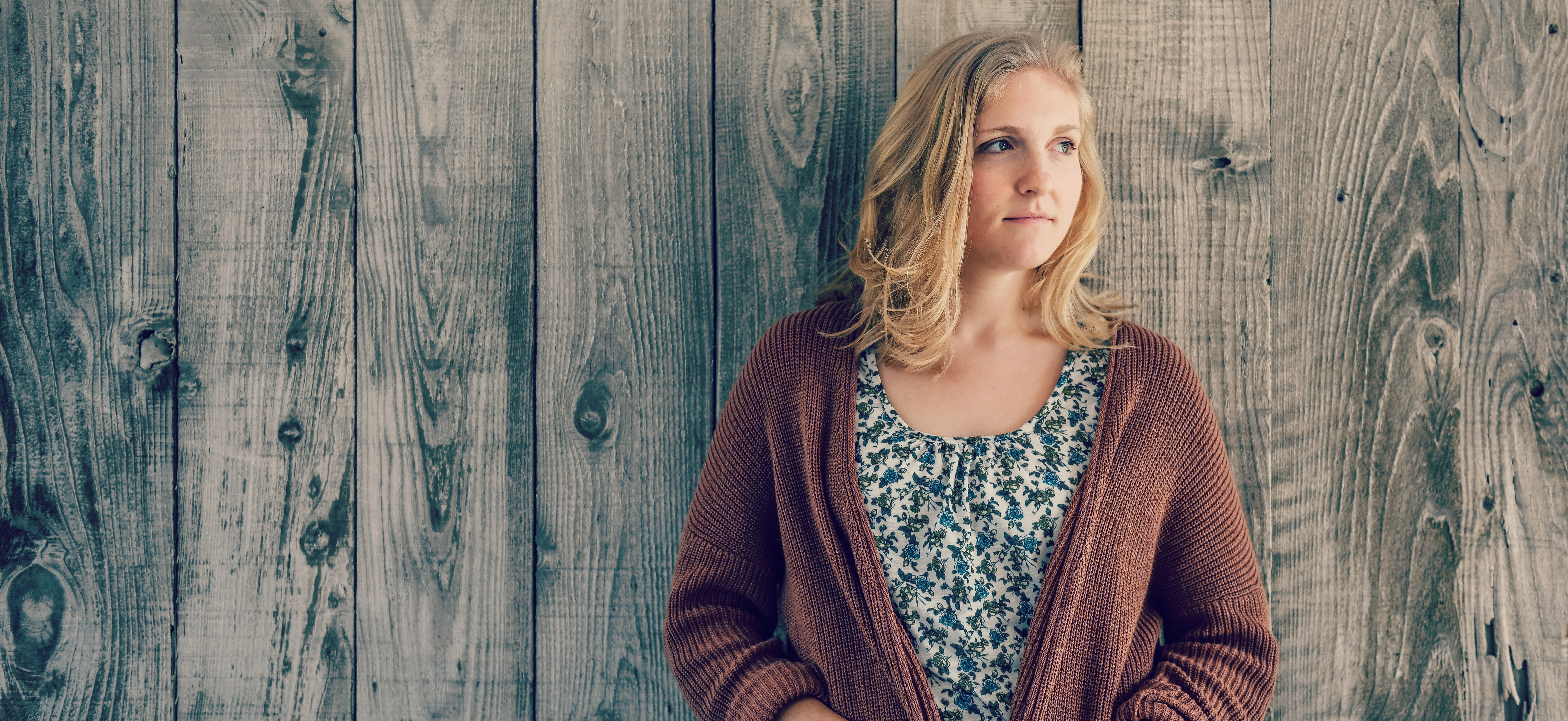 woman leaning on a wall staring off into the distance