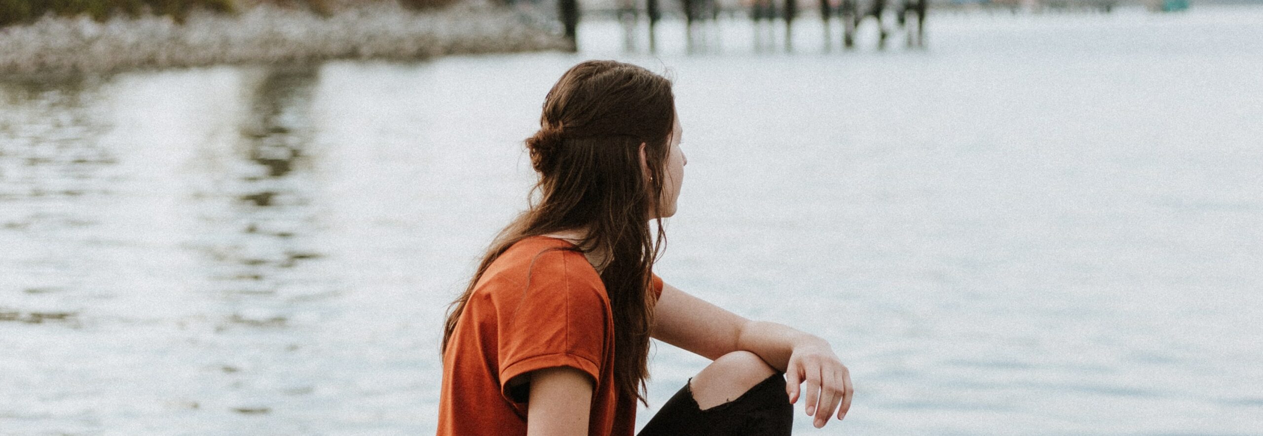 woman sits by lake representing what is addiction