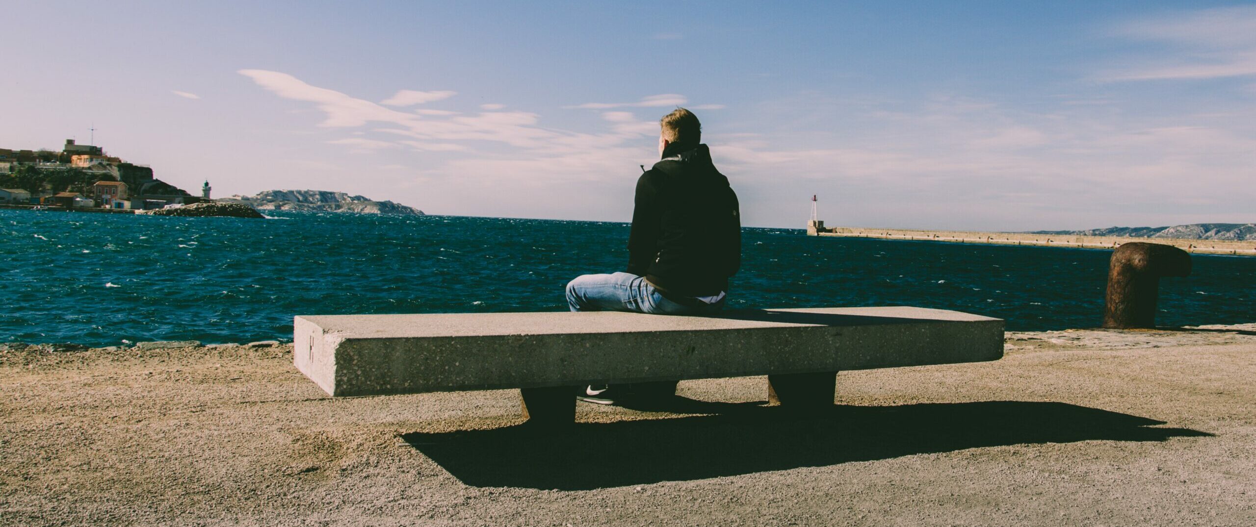 man sitting on bench representing is rehabilitation cheaper than prison.