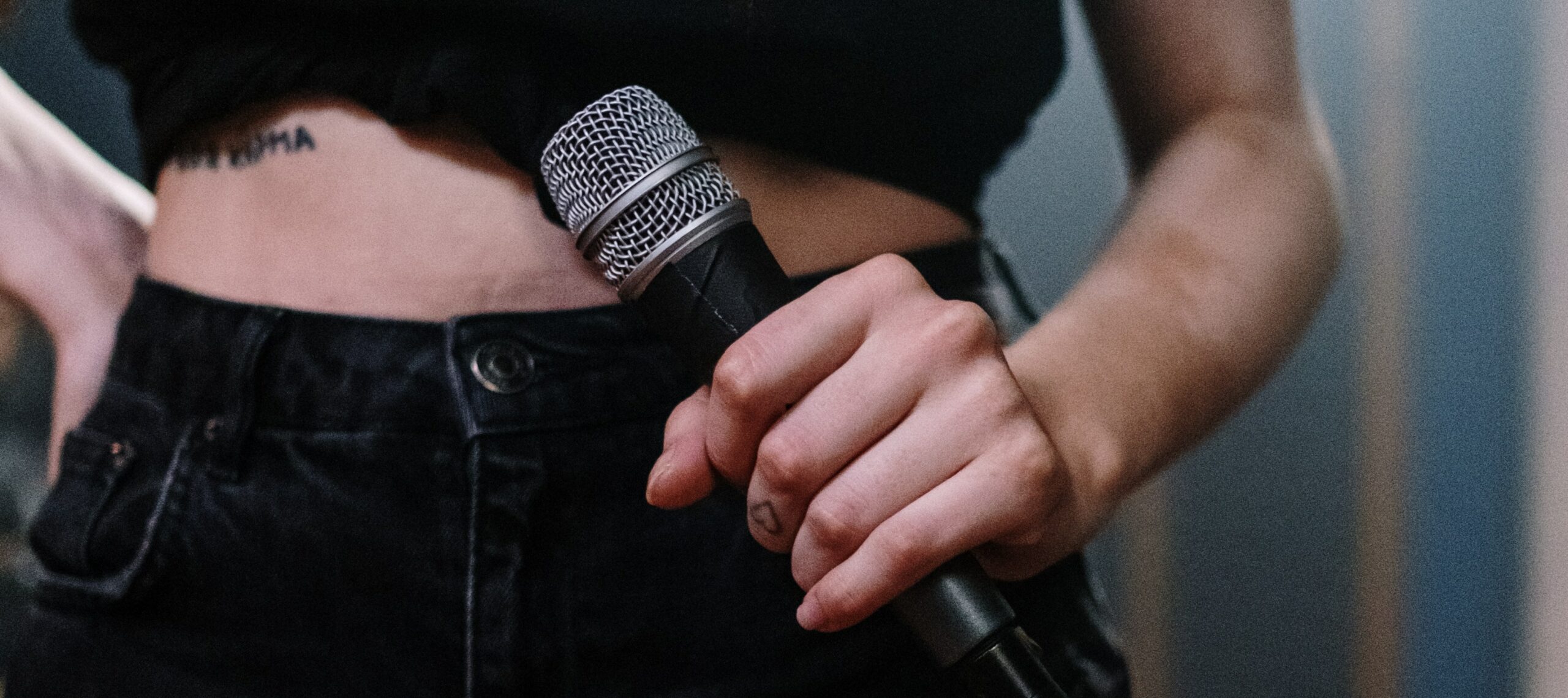 woman holding microphone representing amy winehouse addiction