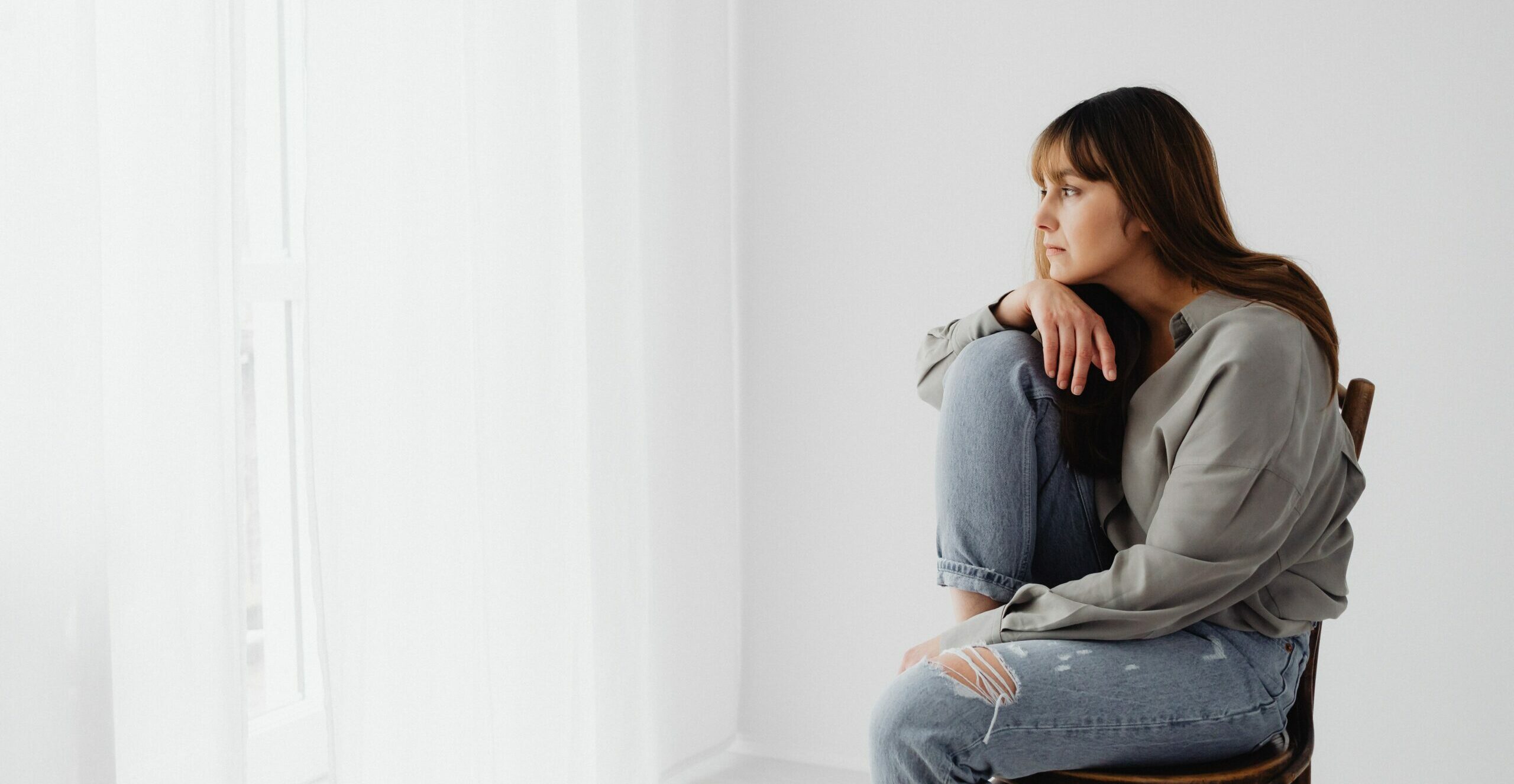 woman looking out a window representing alcohol induced heart attack