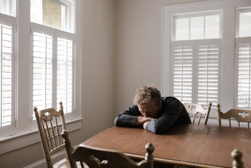 A man sits at a table representing the question can kidneys recover from alcohol damage