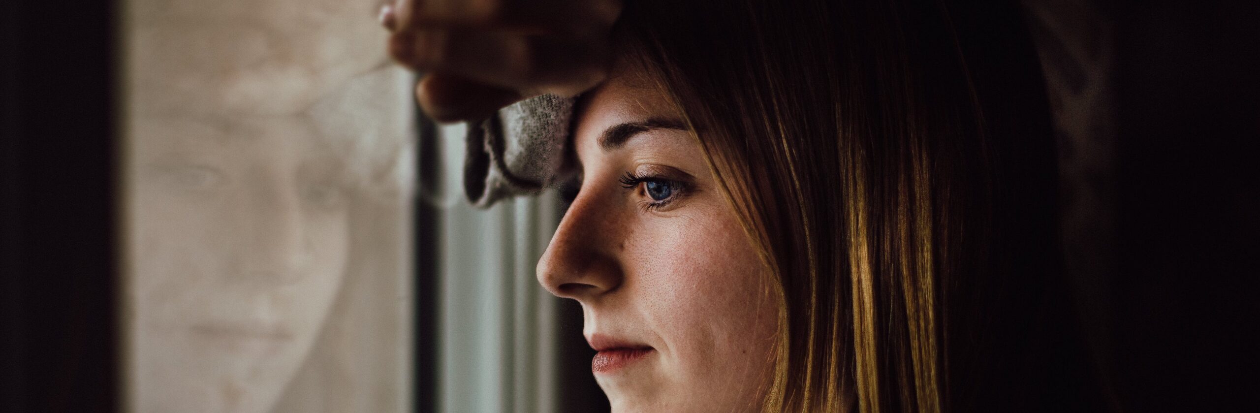 woman looking out window representing Opioid FAQs