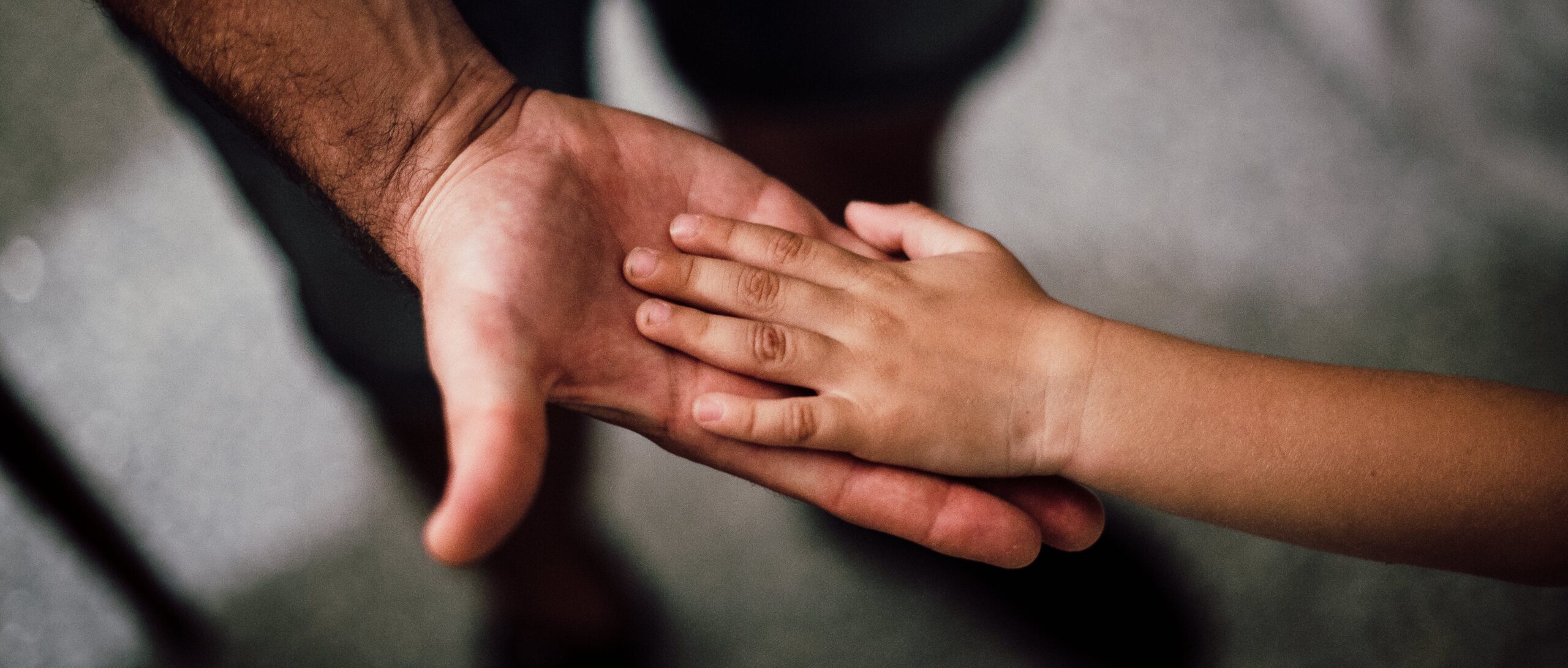 man holding hand of child representing dax shepard sobriety