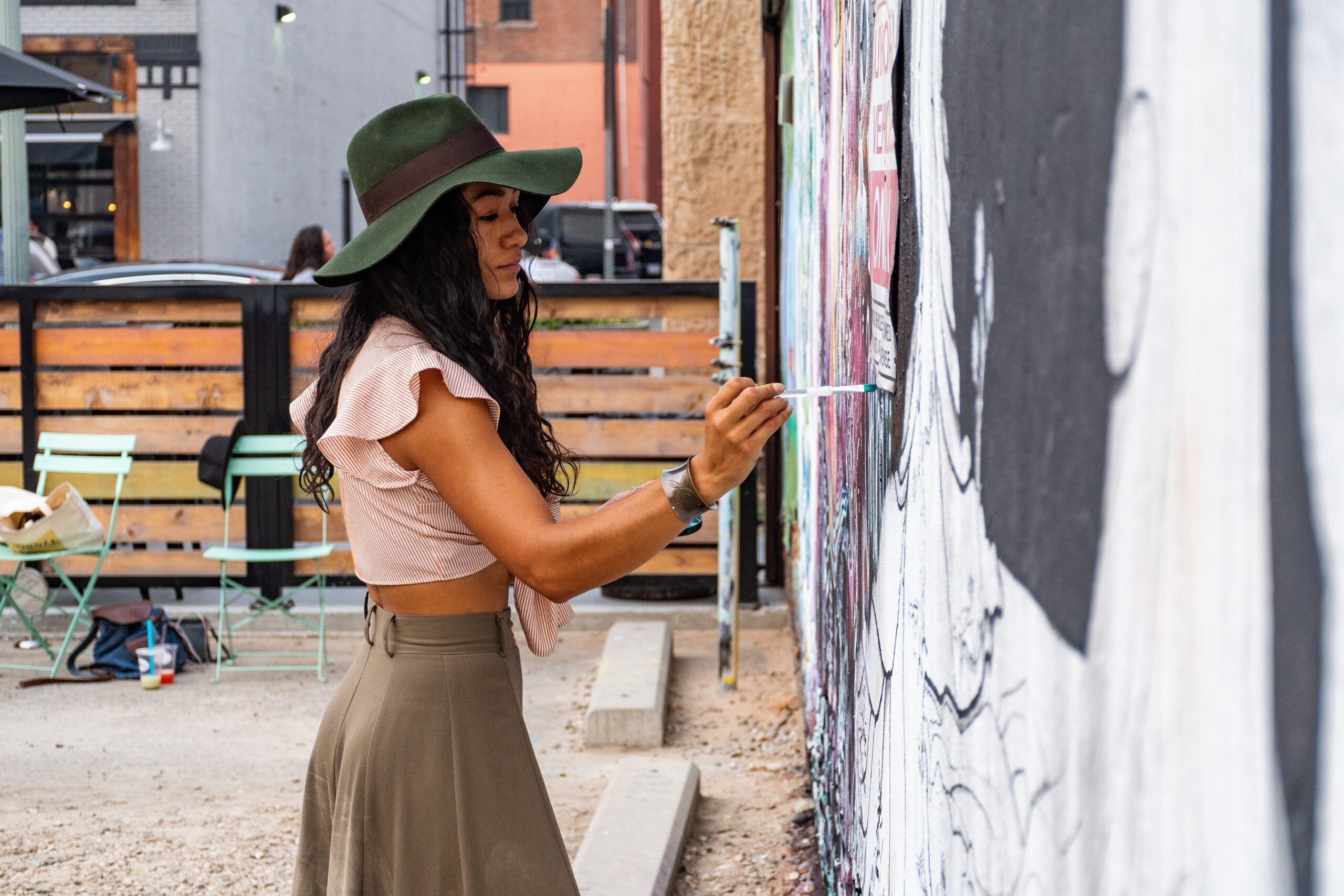 An image of woman painting a mural, engaging in creative and expressive art therapy