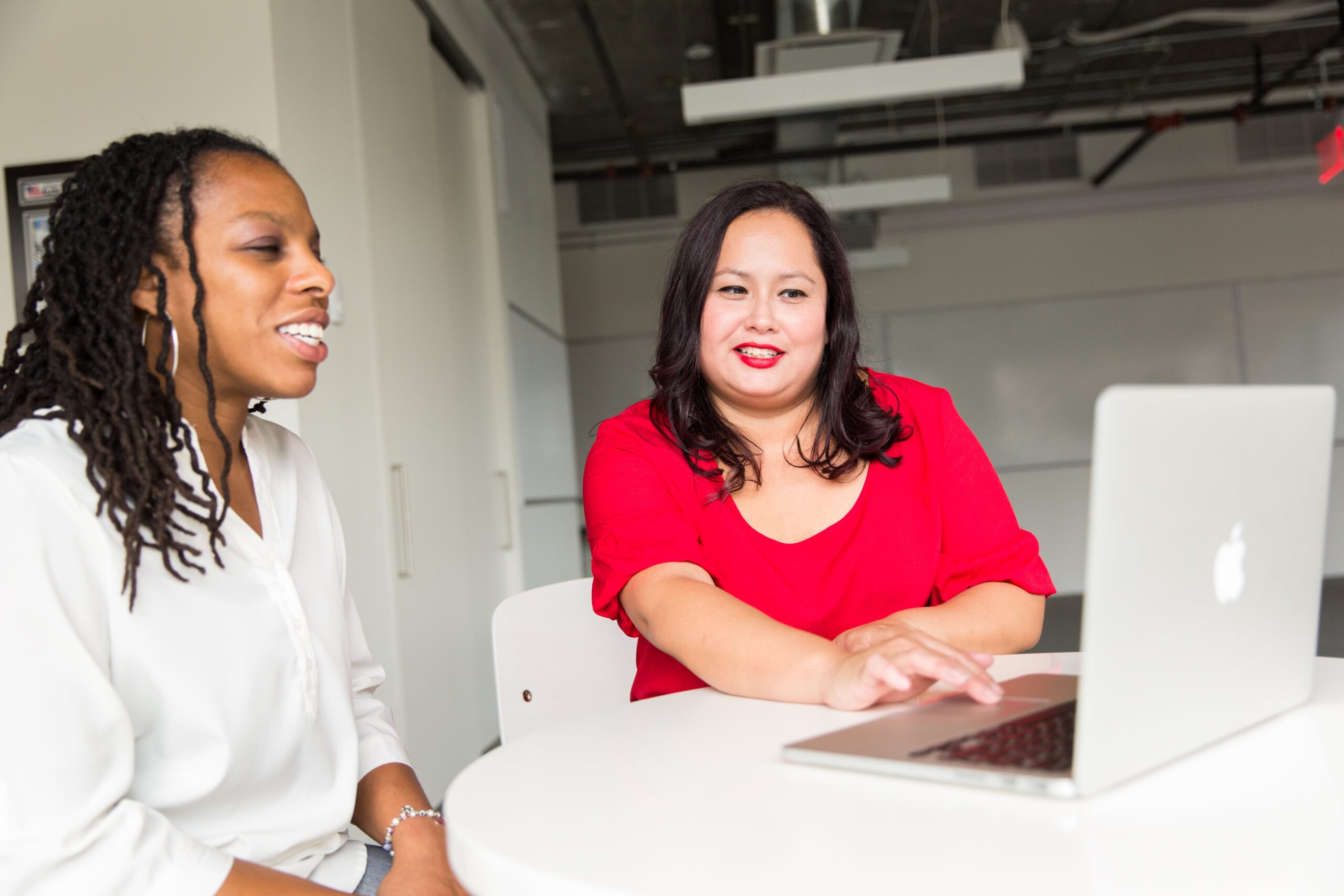 2 women sitting together looking at a laptop together