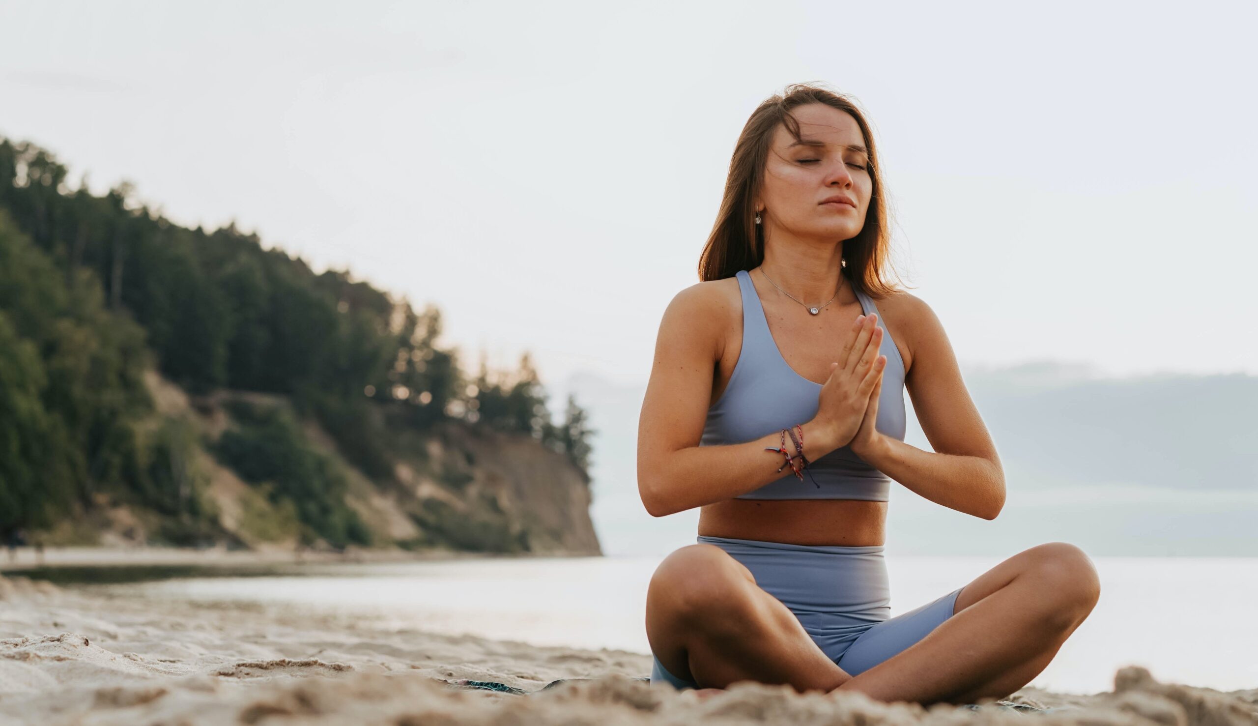 woman doing yoga on the beach