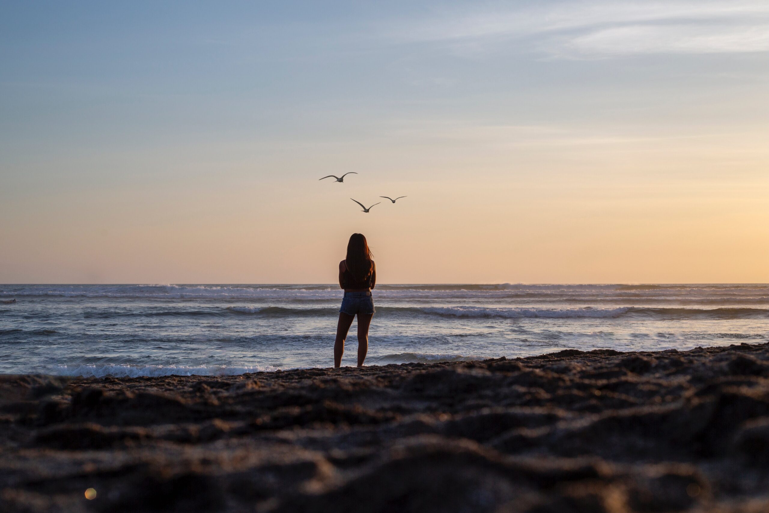 A woman walking on the beach trying to determine how to process trauma