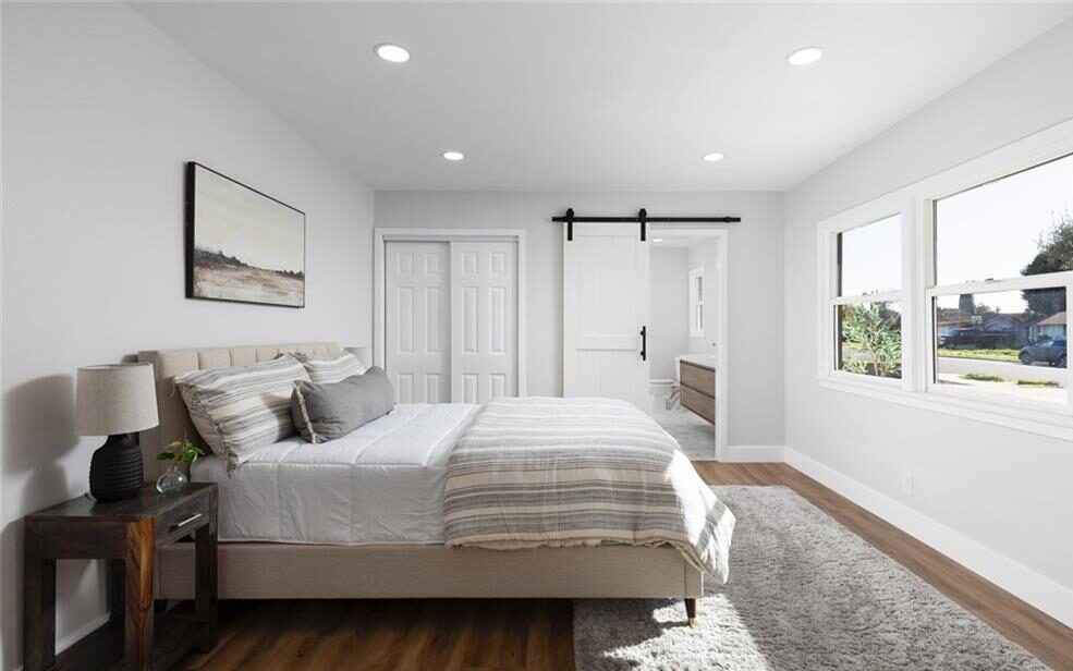 Bedroom with a single bed facing the wall with the windows