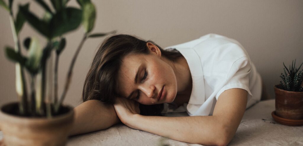 woman resting her head on a table representing how long does sobriety fatigue last