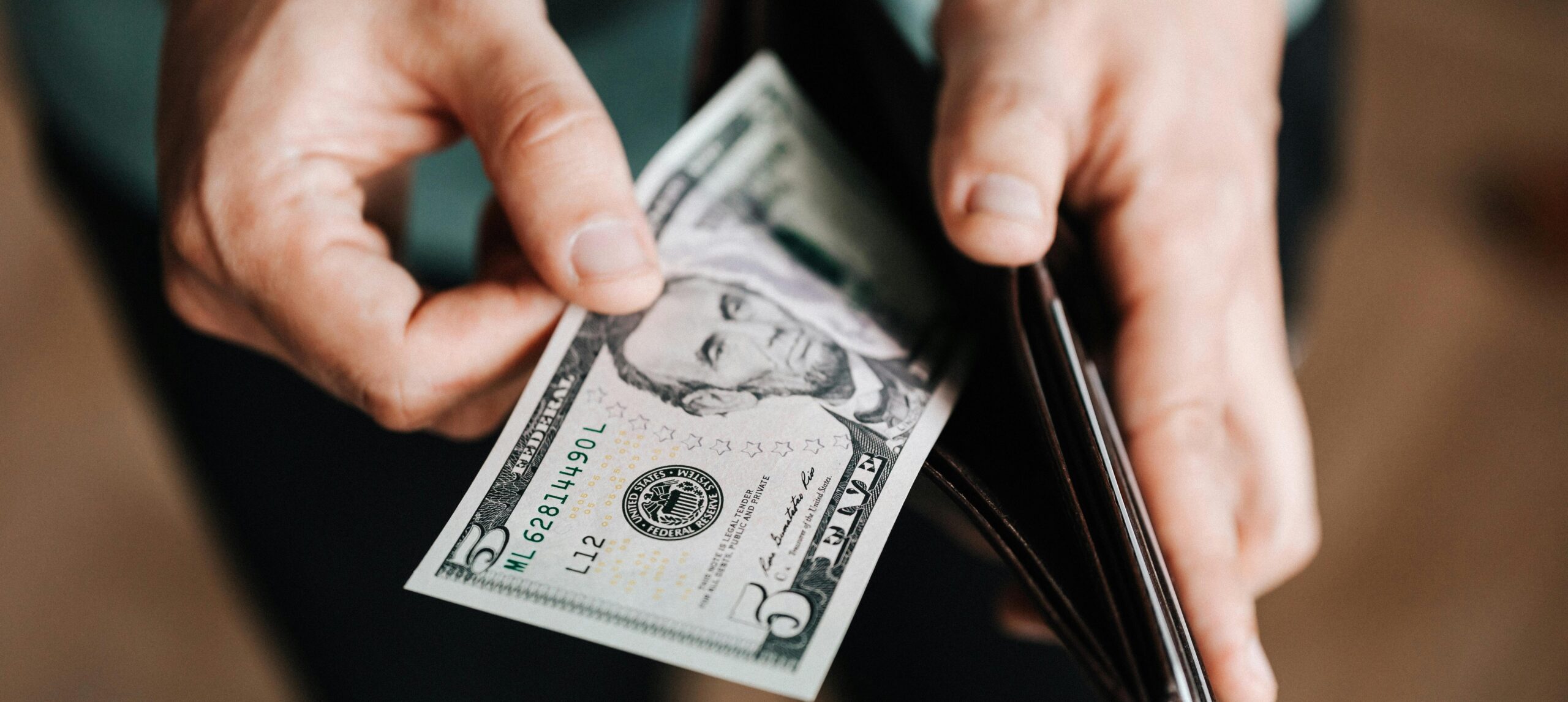 person holding money representing the cost of alcoholism